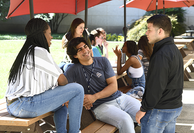 Students sit in the courtyard outside.