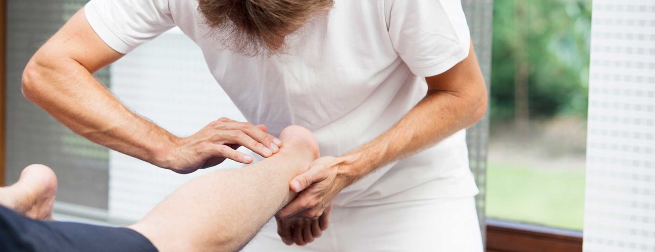 Medical professional examining patient's achilles tendon