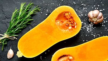 Halved butternut squash with cloves of garlic