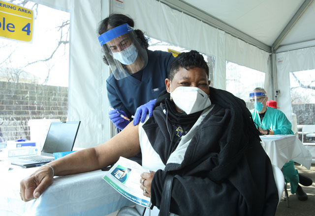 Woman receiving vaccine and community event