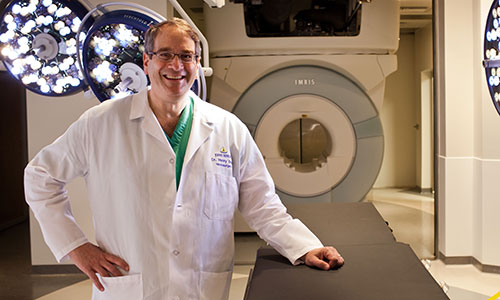 Dr. Henry Brem standing in front of an MRI machine.