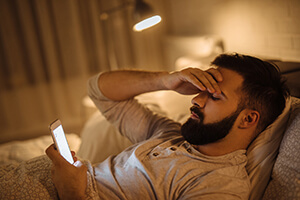 man on phone in bed