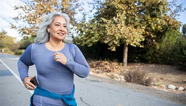 A woman jogging on the side of a road.