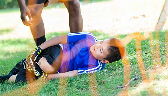 Child with injured knee at soccer game.