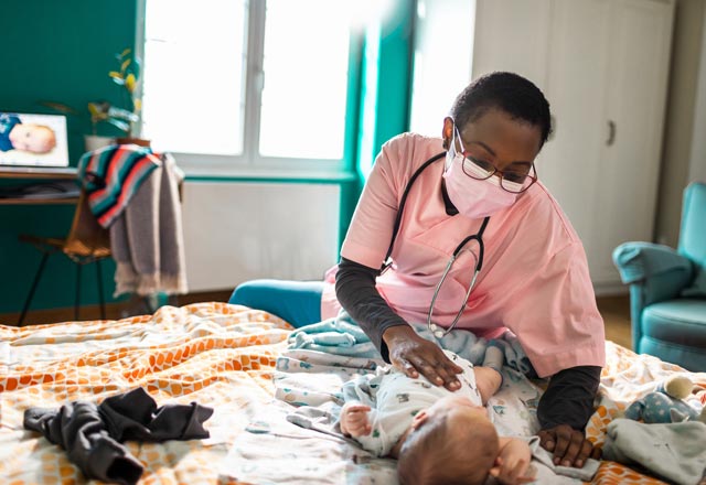 Physician sitting with adolescent girl in hospital bed