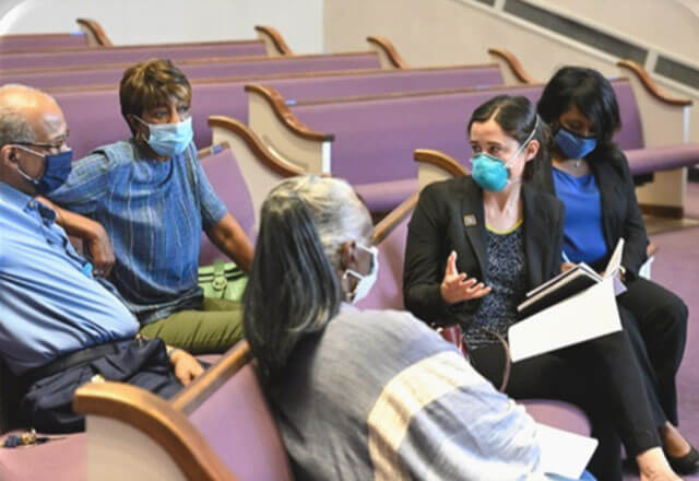 Masked congregation in a house of worship listening to recommendations for reopening their house of worship