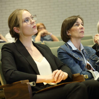 Audience members listen to presentation