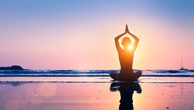 woman doing yoga on beach